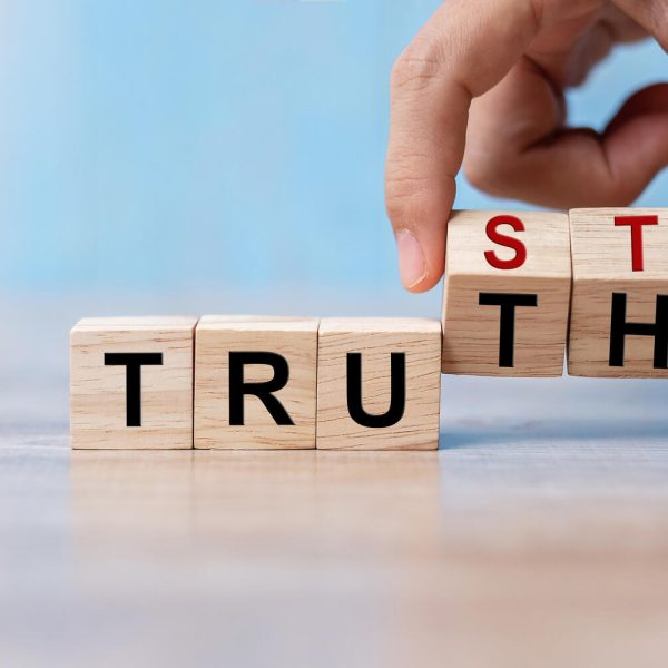 Businessman hand change wooden cube block with TRUST and TRUTH business word on table background. Trustworthy, Truth, beliefs and agreement concept